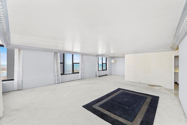 interior space featuring carpet flooring, ornamental molding, and a notable chandelier