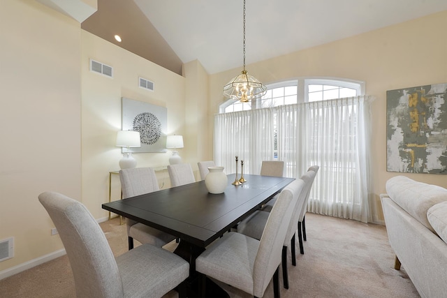 carpeted dining area featuring lofted ceiling and a chandelier