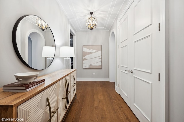 corridor with an inviting chandelier and dark wood-type flooring