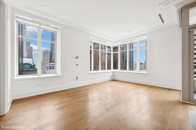 spare room with hardwood / wood-style floors and ornamental molding