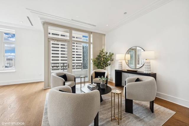 living area featuring hardwood / wood-style flooring and ornamental molding