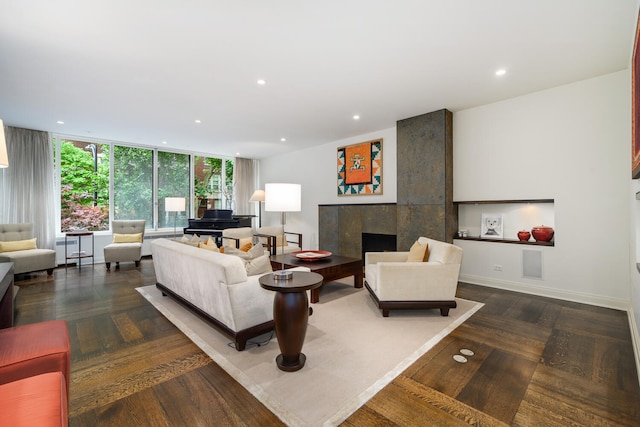 living room with a fireplace, dark hardwood / wood-style flooring, and floor to ceiling windows