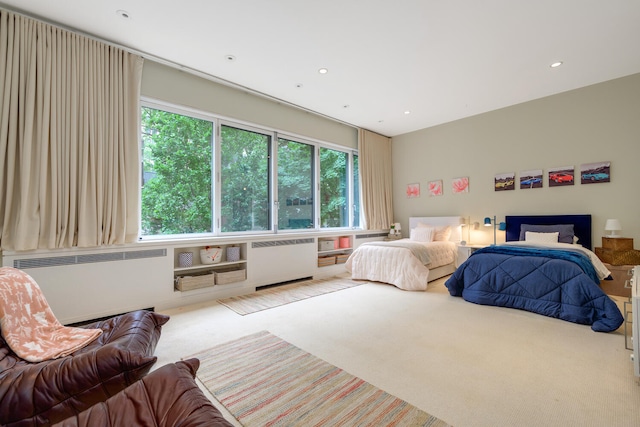 carpeted bedroom featuring radiator heating unit and multiple windows