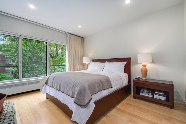 bedroom featuring radiator heating unit and light hardwood / wood-style flooring