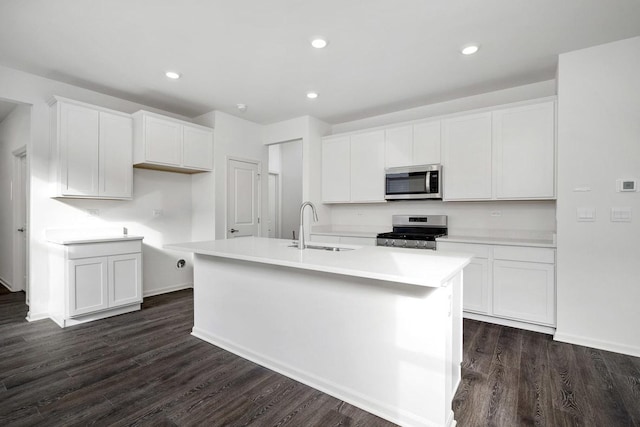 kitchen featuring stainless steel appliances, white cabinetry, a kitchen island with sink, and sink