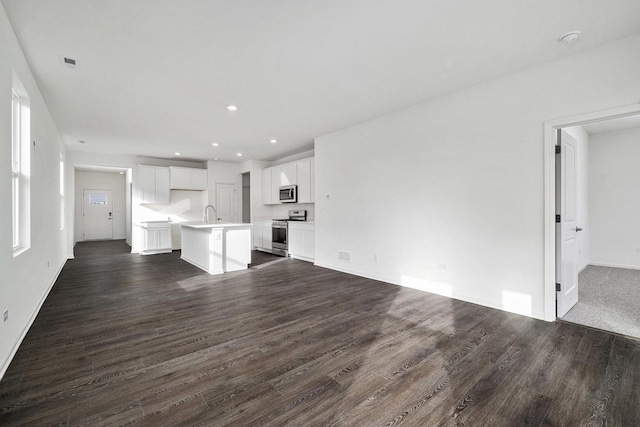 unfurnished living room featuring dark hardwood / wood-style flooring and sink