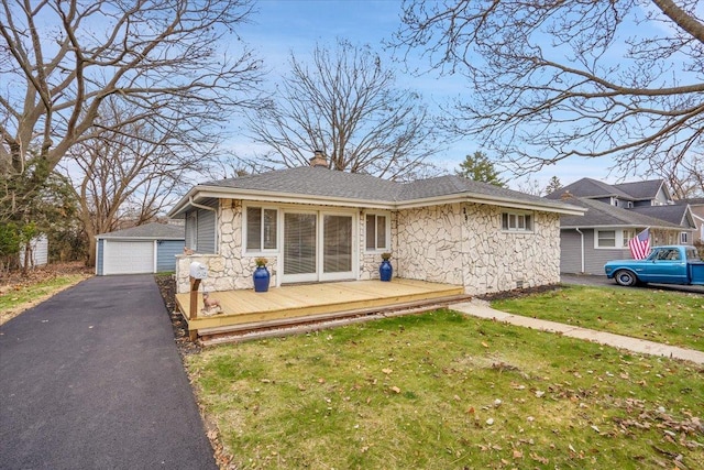 ranch-style house with an outbuilding, a front lawn, and a wooden deck