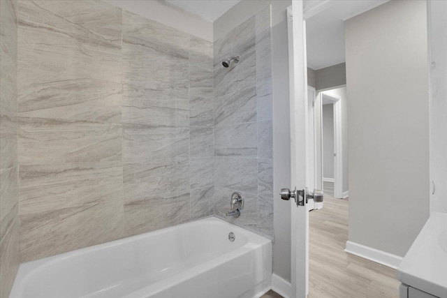 bathroom with hardwood / wood-style floors, vanity, and tiled shower / bath combo