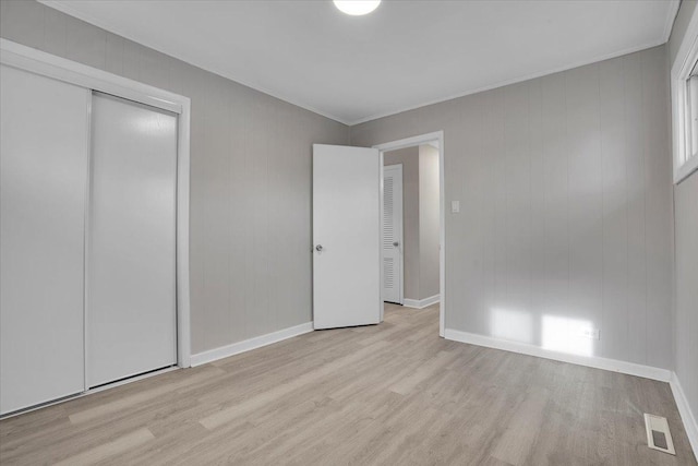 unfurnished bedroom featuring a closet and light wood-type flooring