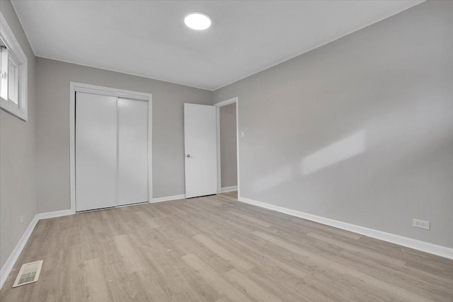 unfurnished bedroom with light hardwood / wood-style floors and a closet