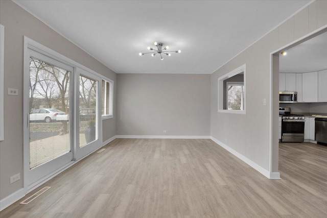 unfurnished dining area featuring light hardwood / wood-style floors and a chandelier