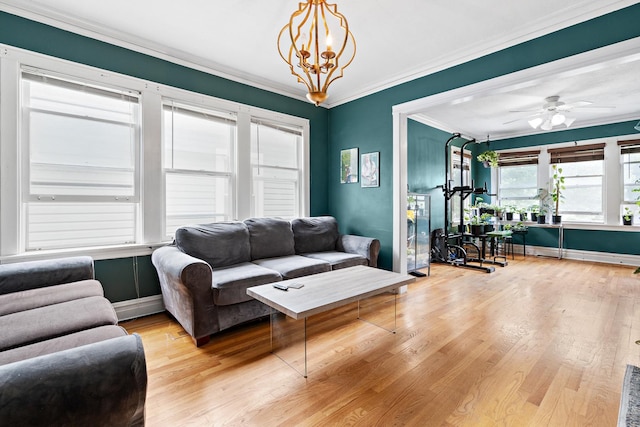 living room featuring light hardwood / wood-style flooring, ceiling fan with notable chandelier, and ornamental molding