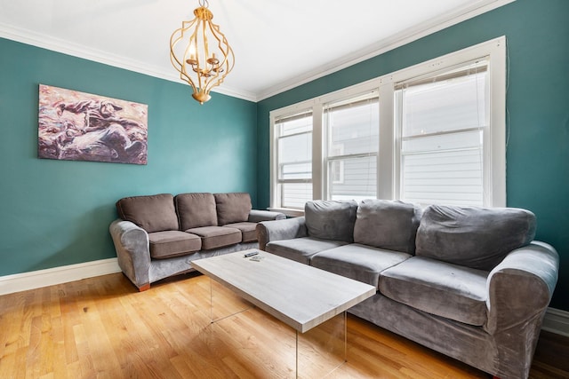 living room featuring light hardwood / wood-style flooring, ornamental molding, and a notable chandelier