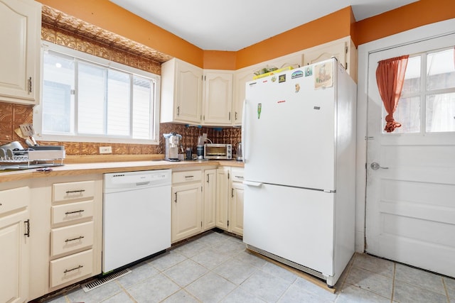 kitchen with white appliances, light tile patterned floors, and tasteful backsplash