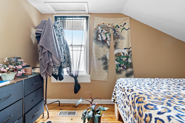 bedroom featuring light hardwood / wood-style flooring and lofted ceiling