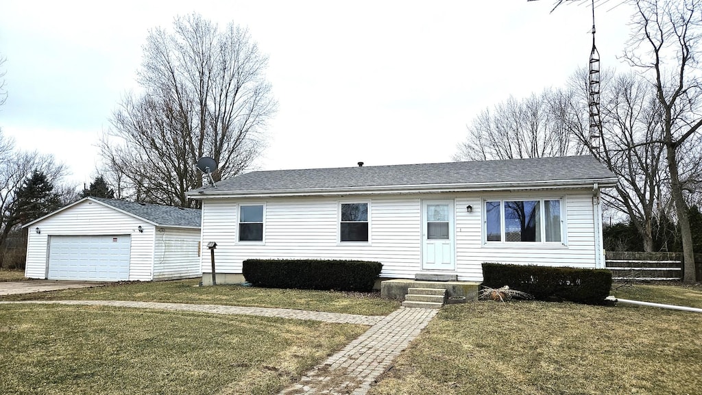 view of front of house with an outbuilding, a front yard, and a garage