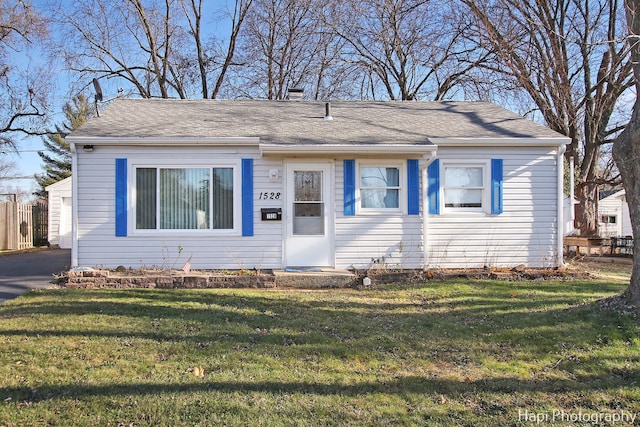 view of front facade featuring a garage, an outbuilding, and a front yard