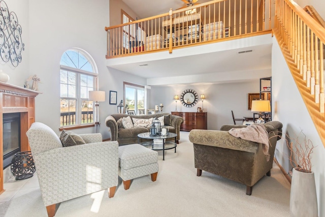 living room with a towering ceiling and light carpet