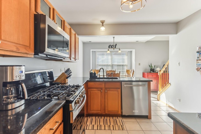 kitchen featuring an inviting chandelier, sink, decorative light fixtures, light tile patterned flooring, and stainless steel appliances