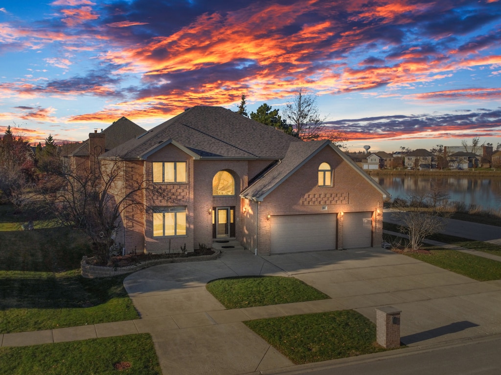 view of front of home with a garage and a water view