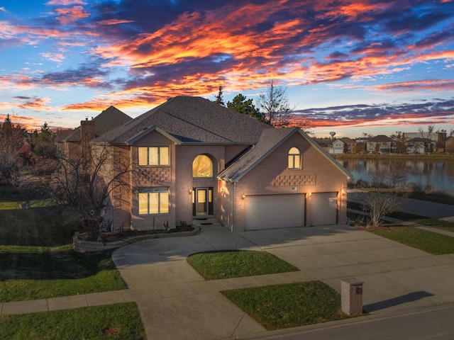 view of front of home with a garage and a water view