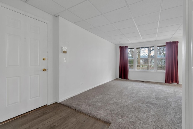 carpeted spare room featuring a paneled ceiling