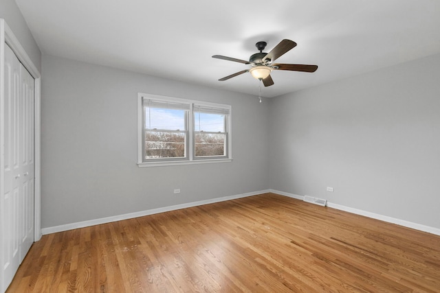 unfurnished bedroom featuring ceiling fan, a closet, and wood-type flooring