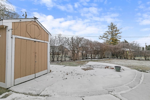 yard layered in snow with a storage shed