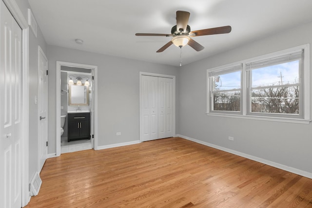 unfurnished bedroom with ceiling fan, sink, ensuite bathroom, and light hardwood / wood-style floors