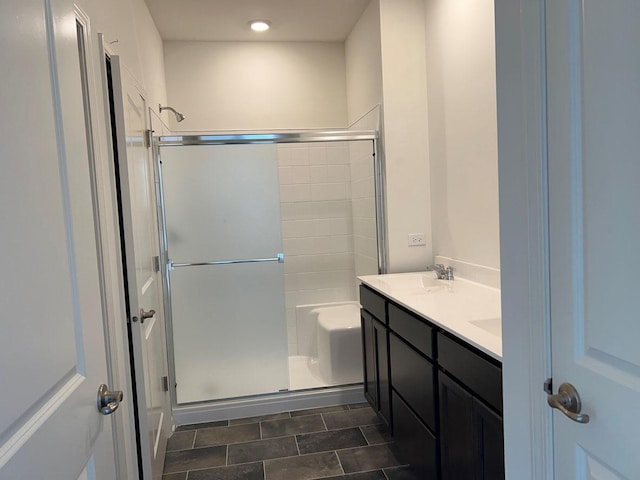 bathroom with vanity and a shower with door