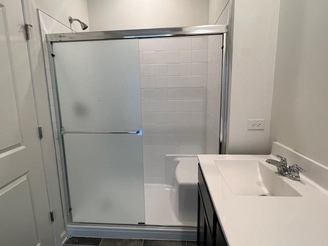 bathroom featuring tile patterned flooring, vanity, and a shower with door