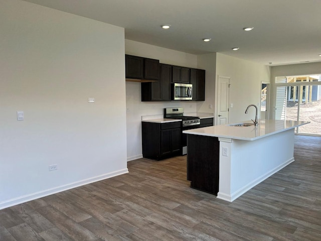 kitchen featuring a center island with sink, hardwood / wood-style flooring, sink, and appliances with stainless steel finishes