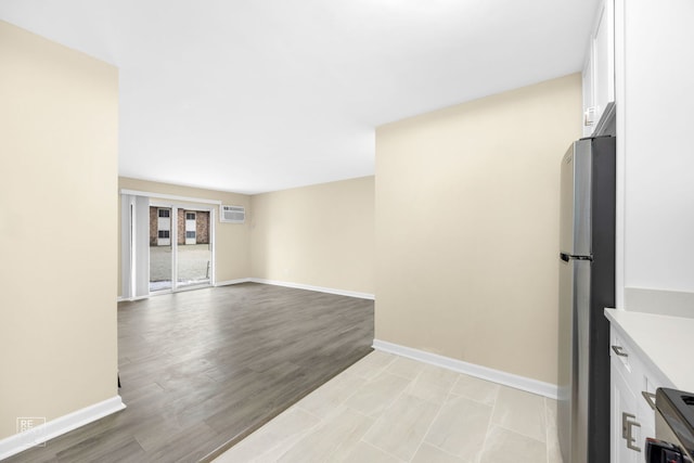 interior space with a wall mounted air conditioner and light hardwood / wood-style floors