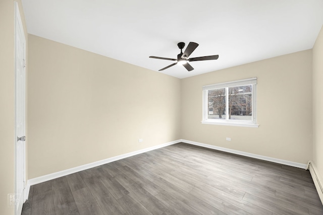 spare room with dark hardwood / wood-style floors, baseboard heating, and ceiling fan