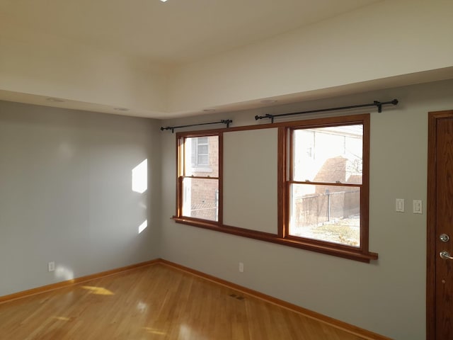 spare room with hardwood / wood-style floors and a healthy amount of sunlight