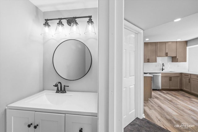 bathroom with vanity, hardwood / wood-style floors, and backsplash