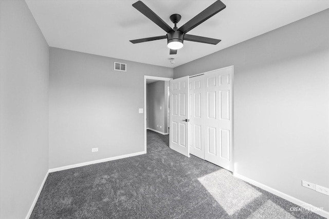 unfurnished bedroom featuring a closet, dark carpet, and ceiling fan