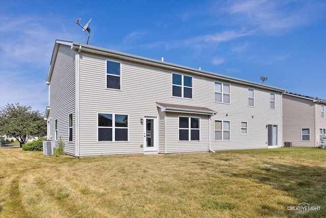 back of property featuring a yard and central AC