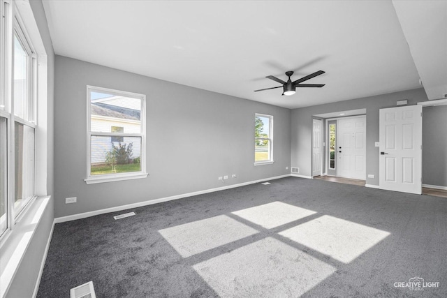 carpeted spare room featuring ceiling fan and a healthy amount of sunlight