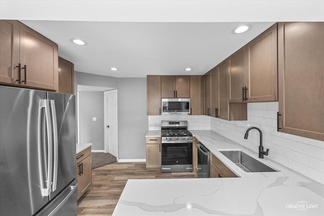 kitchen with light stone countertops, stainless steel appliances, dark hardwood / wood-style floors, and sink