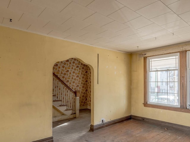 empty room with hardwood / wood-style flooring and ornamental molding