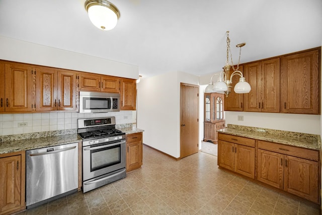 kitchen with light stone countertops, hanging light fixtures, stainless steel appliances, a chandelier, and decorative backsplash