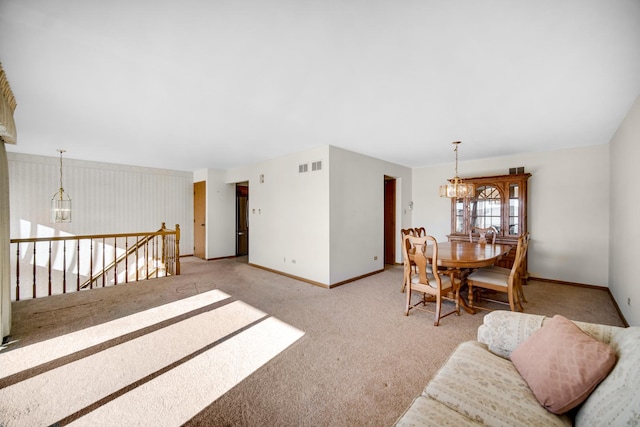 carpeted living room featuring an inviting chandelier