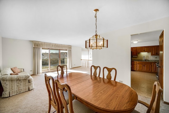 carpeted dining area featuring sink and a chandelier