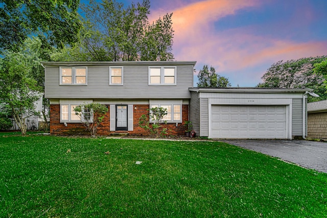 front facade featuring a lawn and a garage