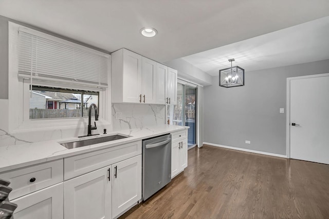 kitchen with pendant lighting, white cabinetry, sink, and stainless steel dishwasher