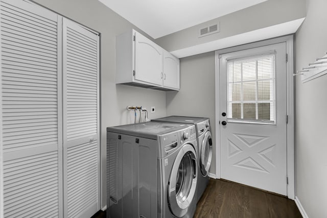 laundry room featuring cabinets, washer and dryer, and dark wood-type flooring