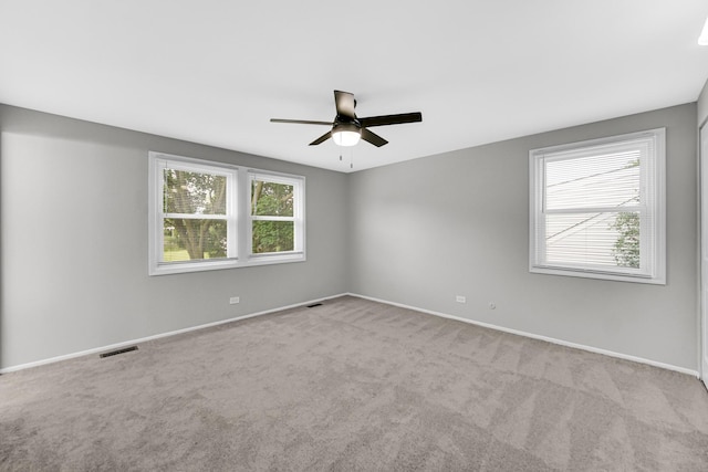 carpeted spare room featuring ceiling fan