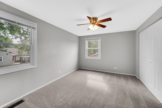 unfurnished bedroom with ceiling fan, carpet floors, and a closet