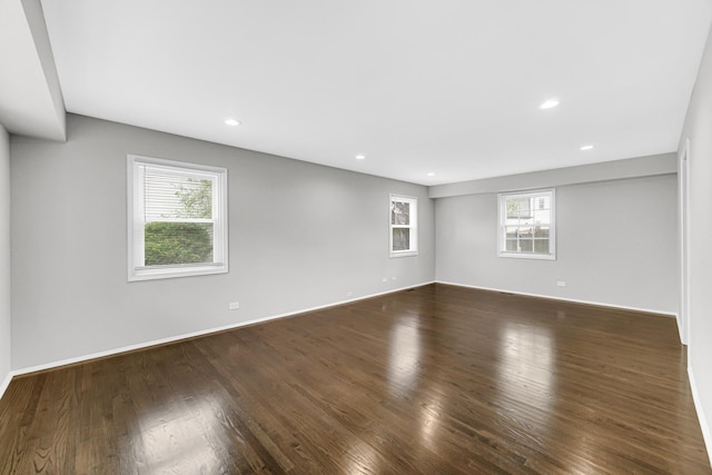 spare room featuring dark hardwood / wood-style flooring and plenty of natural light